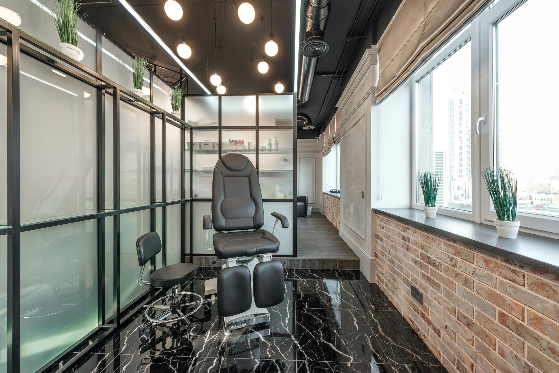 Medical office interior with chair, brick wall, black flooring, and large windows.