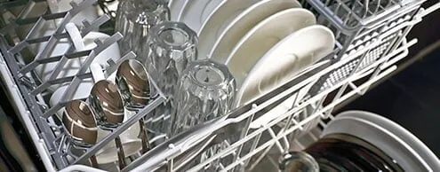 A dishwasher filled with plates , cups , and silverware.