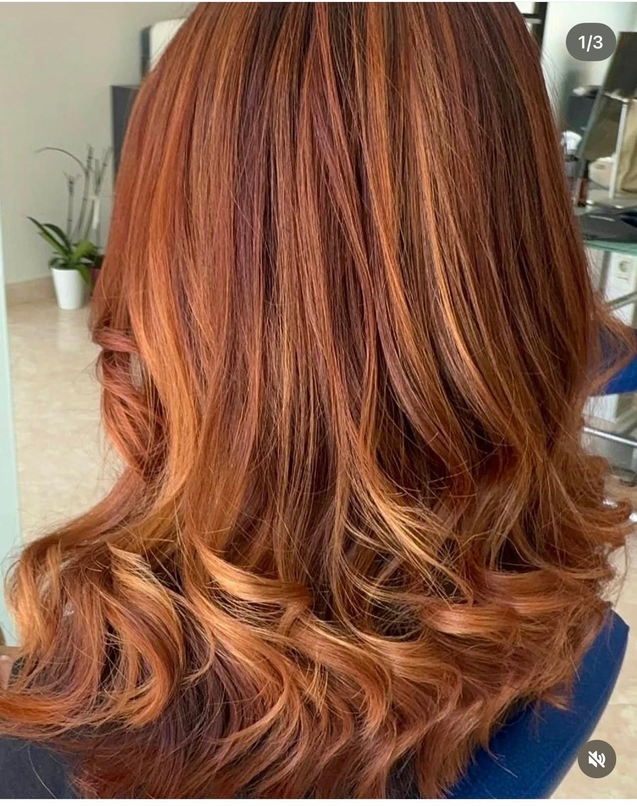 Capelli scalati, mossi, color castano ramato con riflessi caramello, acconciati in morbidi ricci dalla parte posteriore.