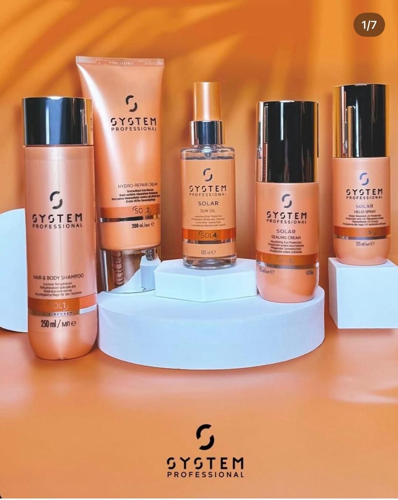 Flaconi e vasetti assortiti di prodotti per la cura della pelle della linea, su supporti color pastello su sfondo arancione.