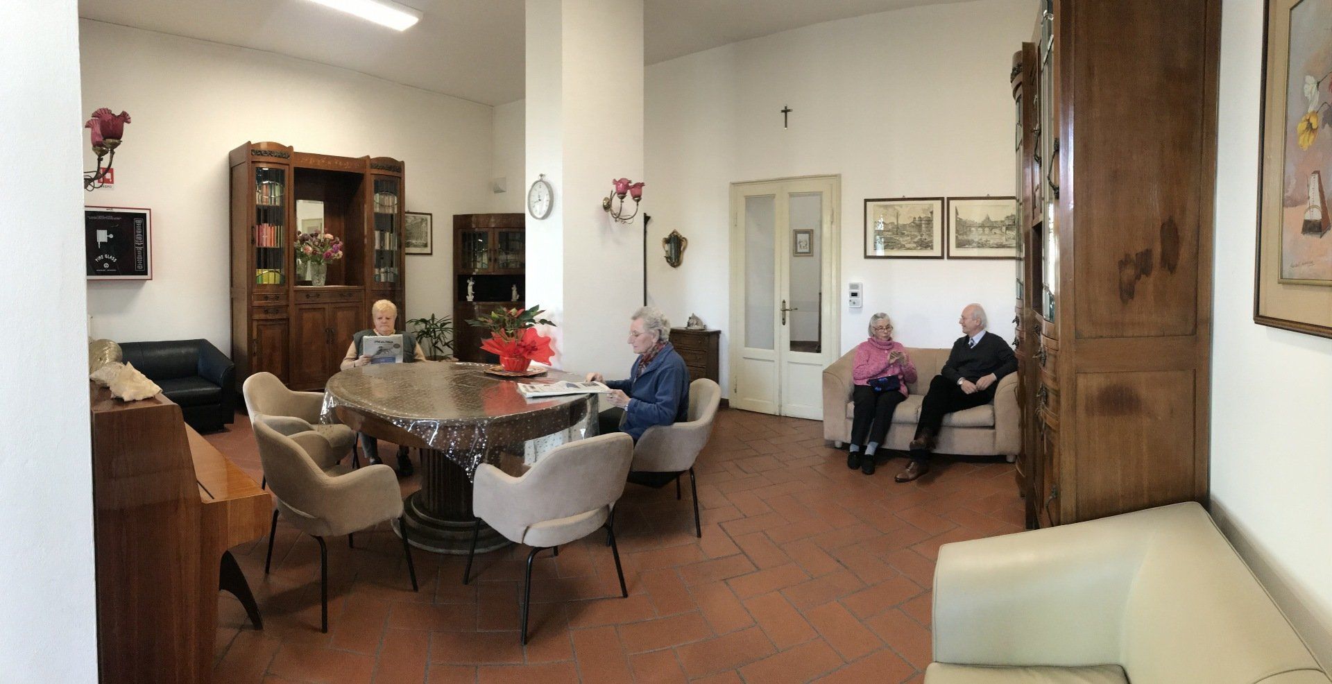 Un gruppo di persone è seduto attorno a un tavolo in un soggiorno.