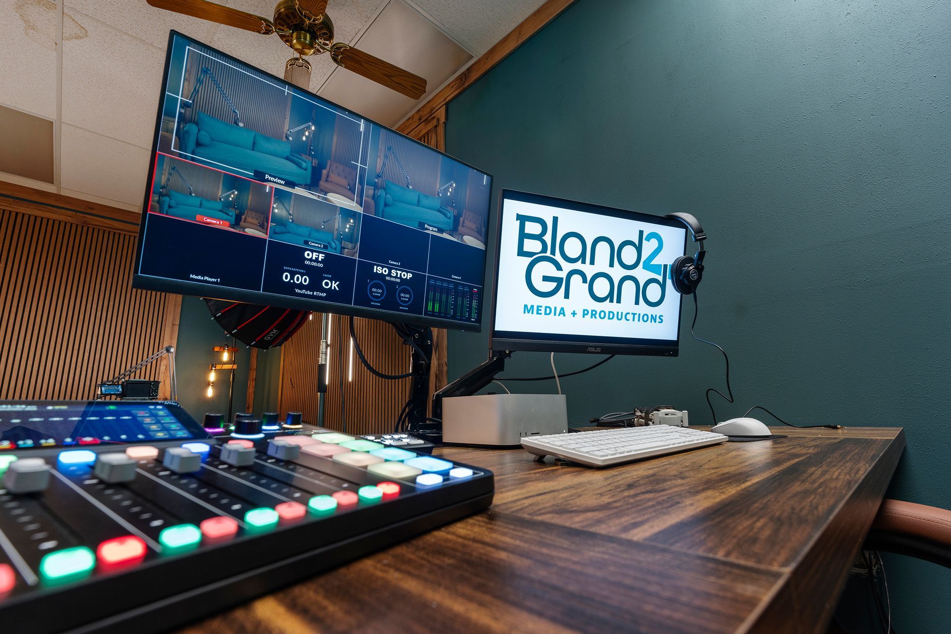 Audio mixing studio desk with monitor, control surface, and screen showing “Bland2 Grand” logo