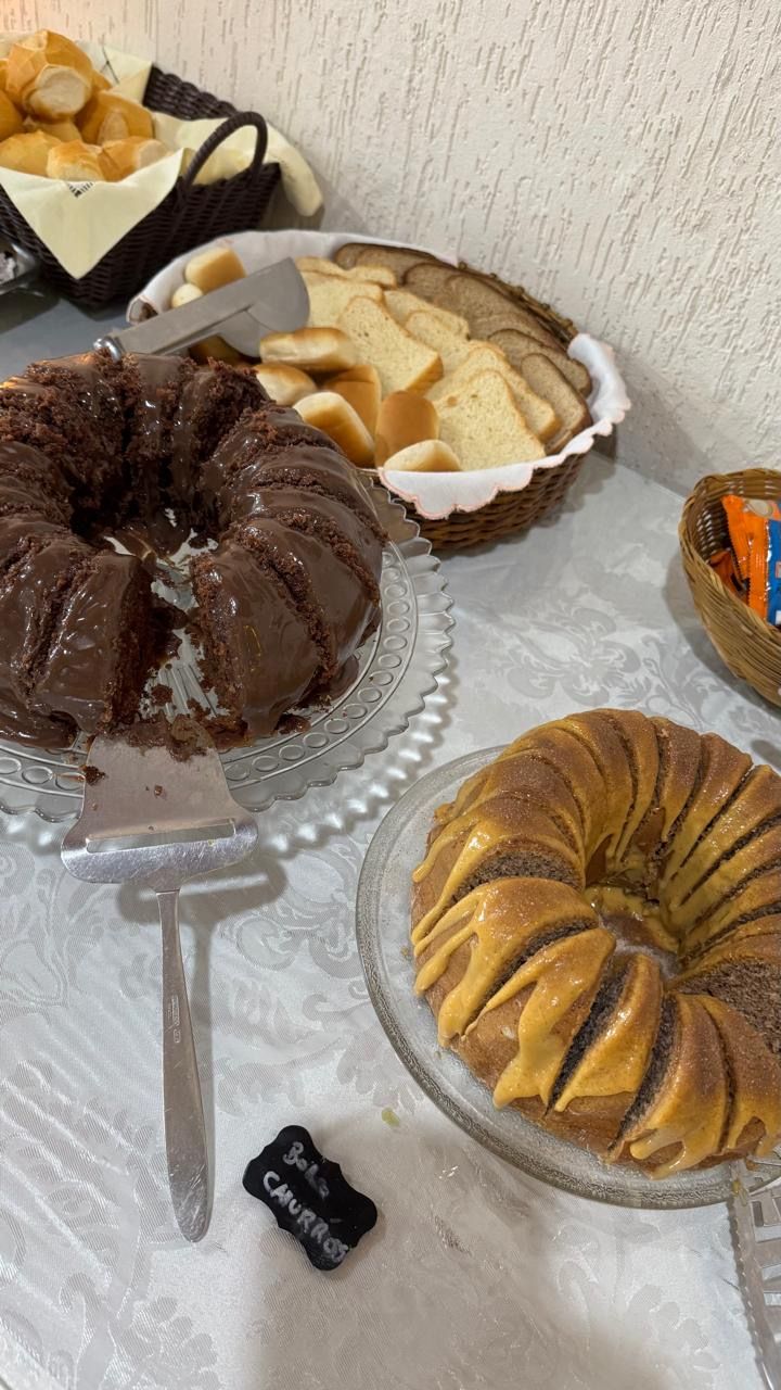 Diversos bolos tipo Bundt dispostos em uma mesa, incluindo bolos de chocolate, baunilha e com cobertura de caramelo.