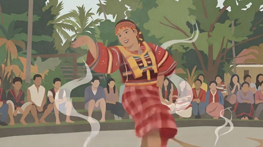 Dancer in red traditional dress performs outdoors before a seated crowd, with trees in the background.