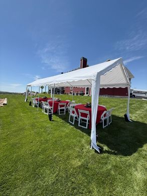 Evening outdoor event setup with rental tables and chairs