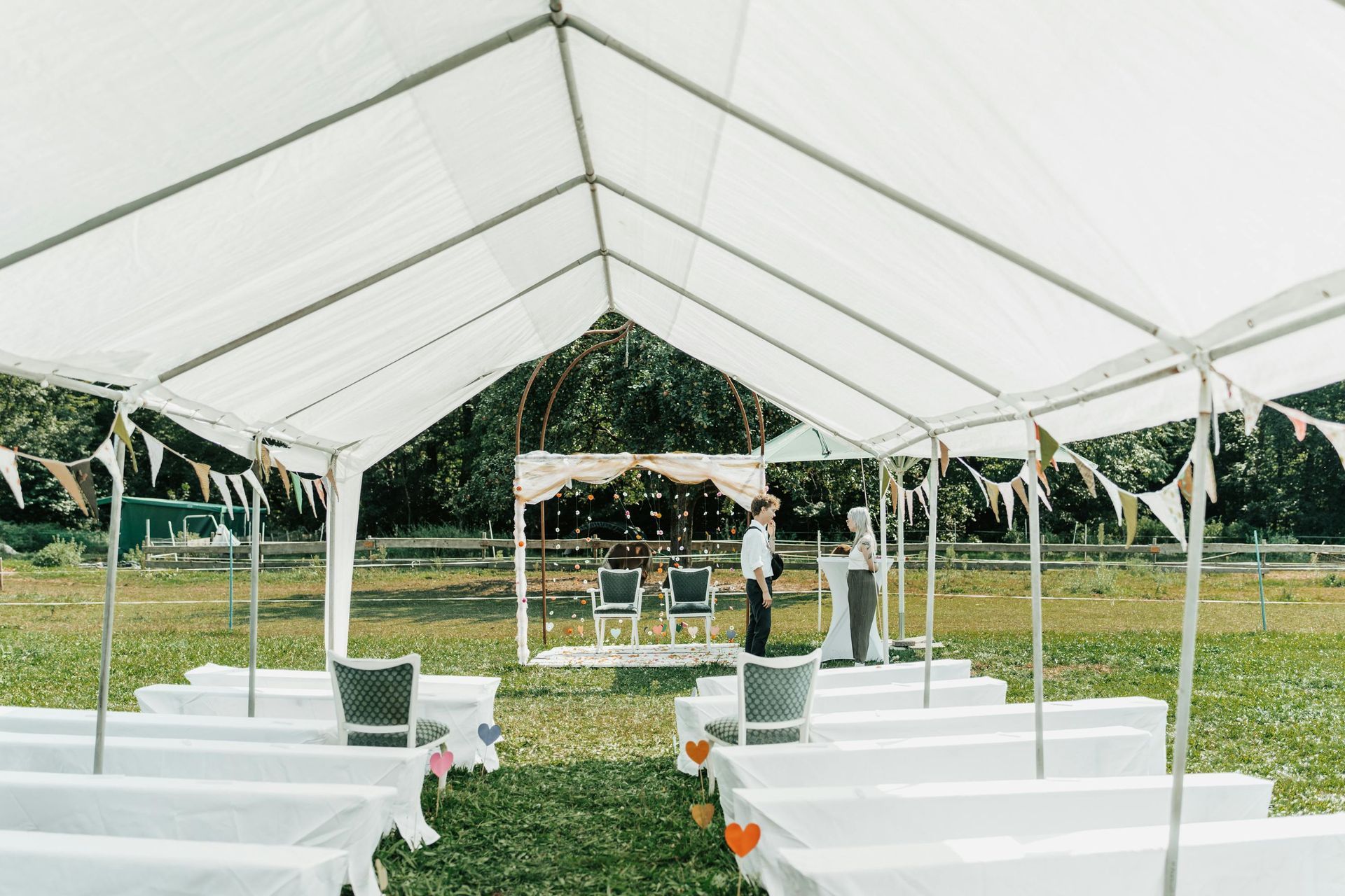 Wedding tent rental with seating arranged for an outdoor ceremony