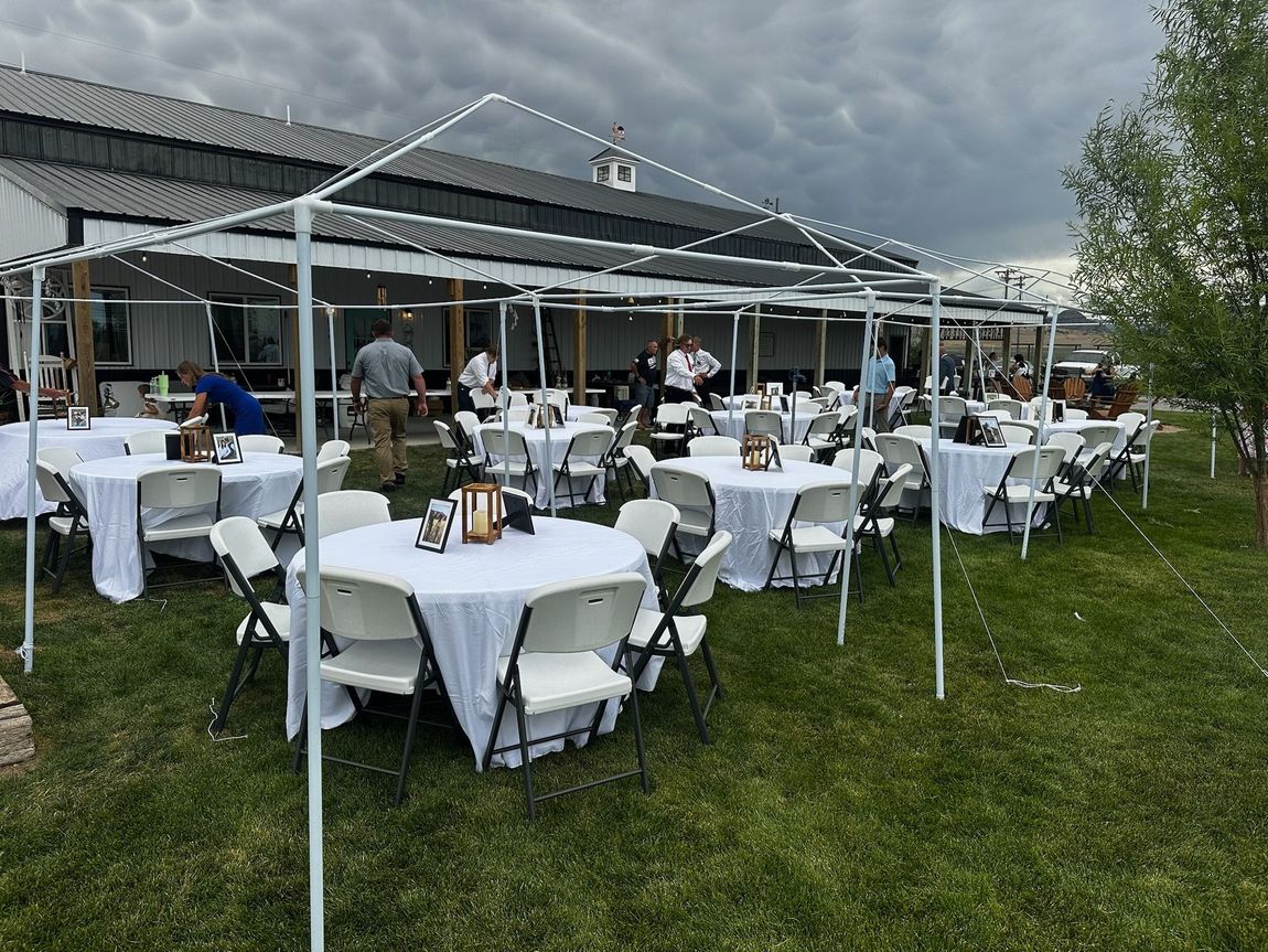 Outdoor tent and shade setup with tables and chairs for an event