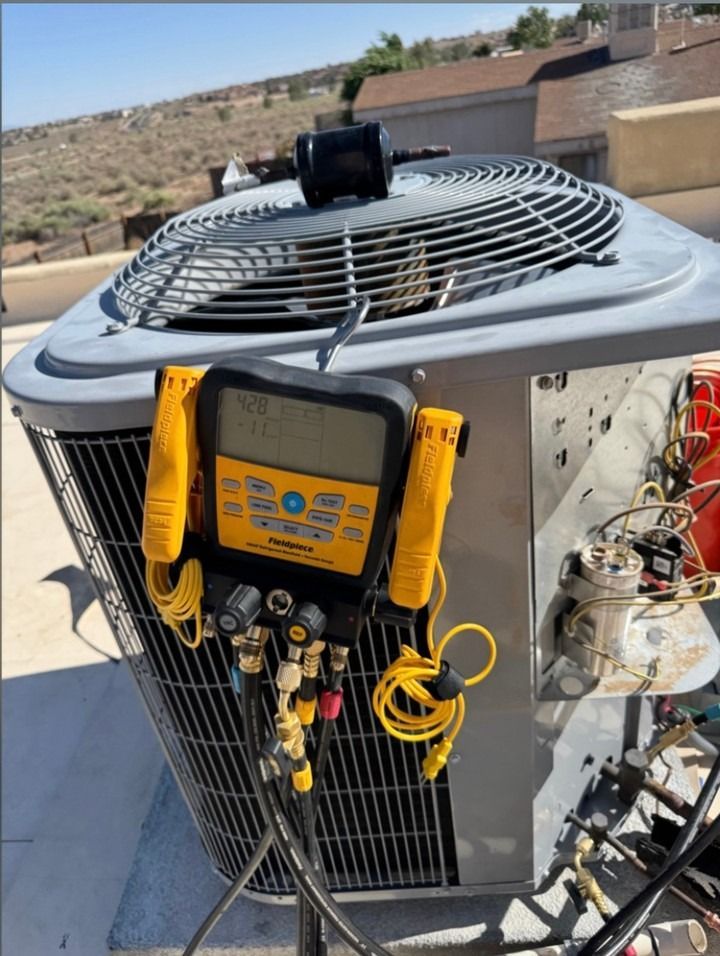 HVAC condenser unit with gauges and yellow service manifold attached outdoors on a rooftop