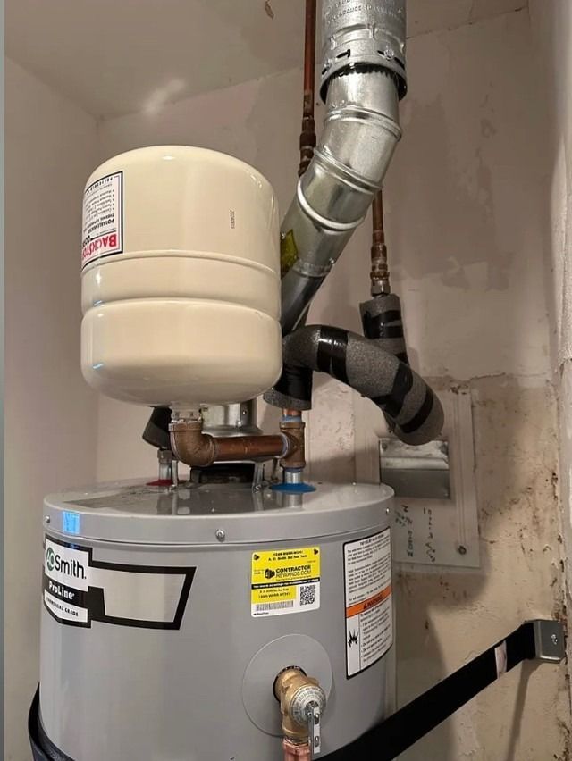 Water heater with a beige expansion tank and silver venting pipes in a utility closet.