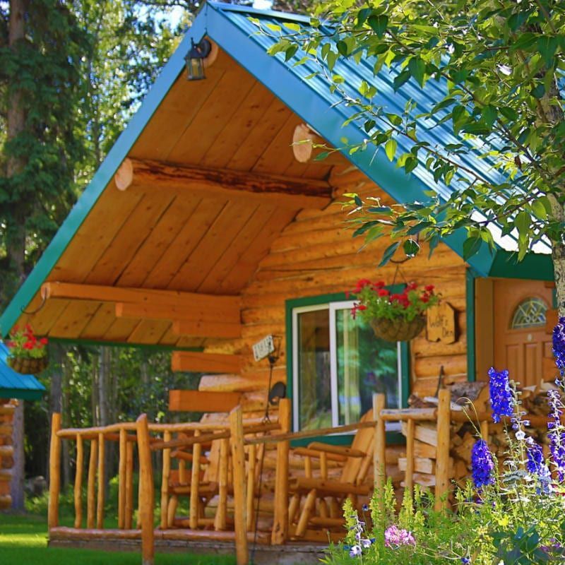 A small log cabin with a blue roof