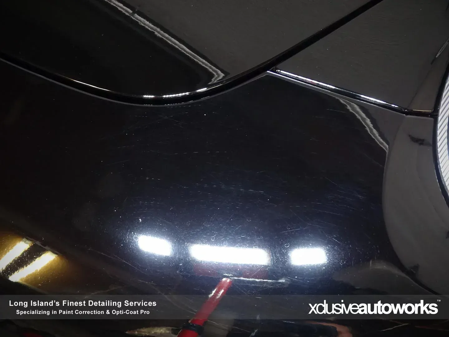 A black car is being cleaned by xclusive autoworks
