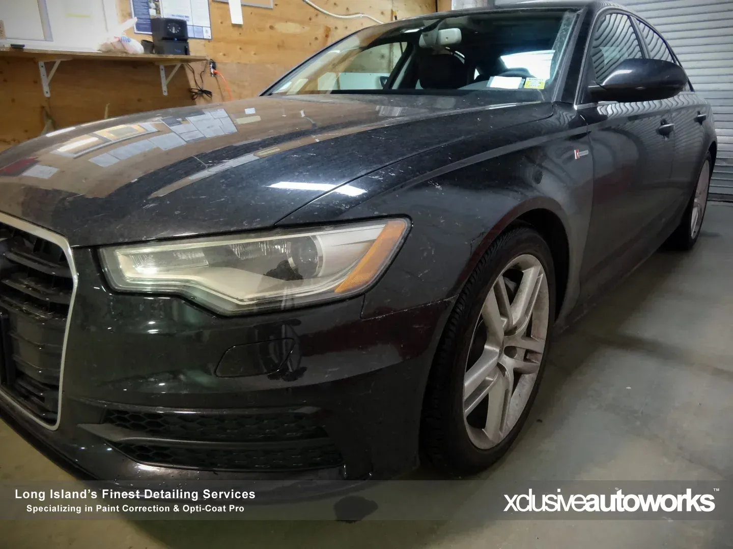 A black audi a6 is parked in a garage.