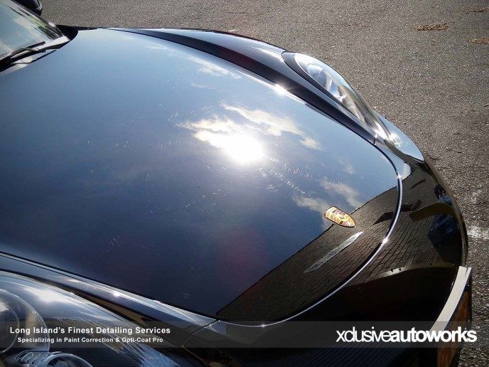 A close up of the hood of a black porsche