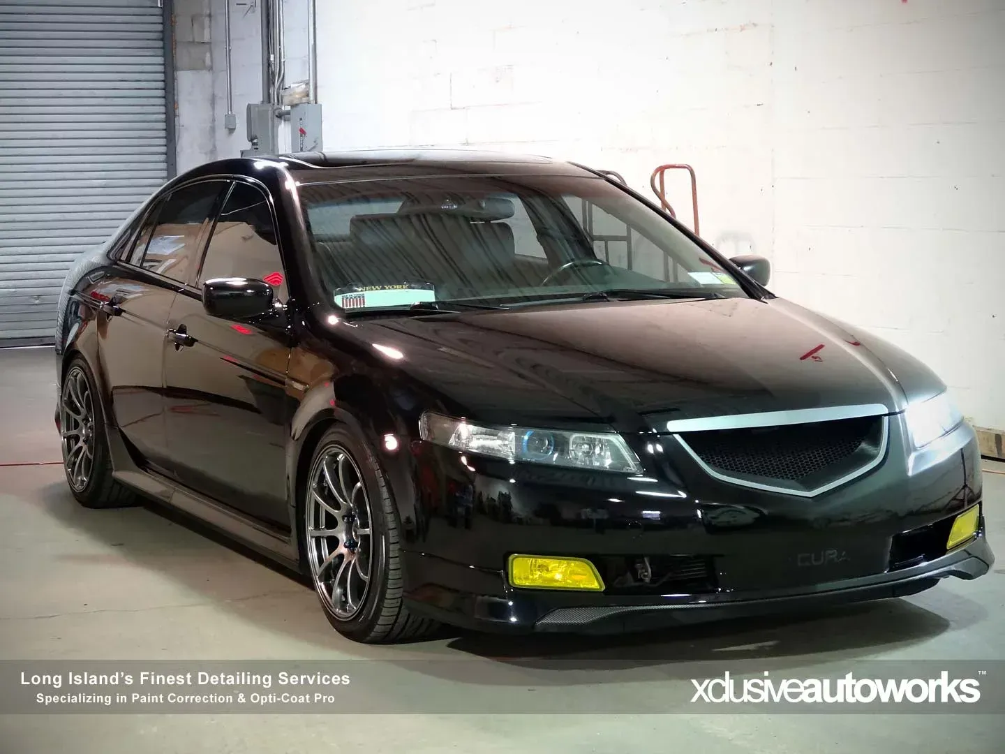 A black car with yellow lights is parked in a garage.