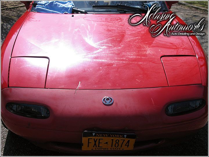 A red sports car with a license plate that says fxe-1874