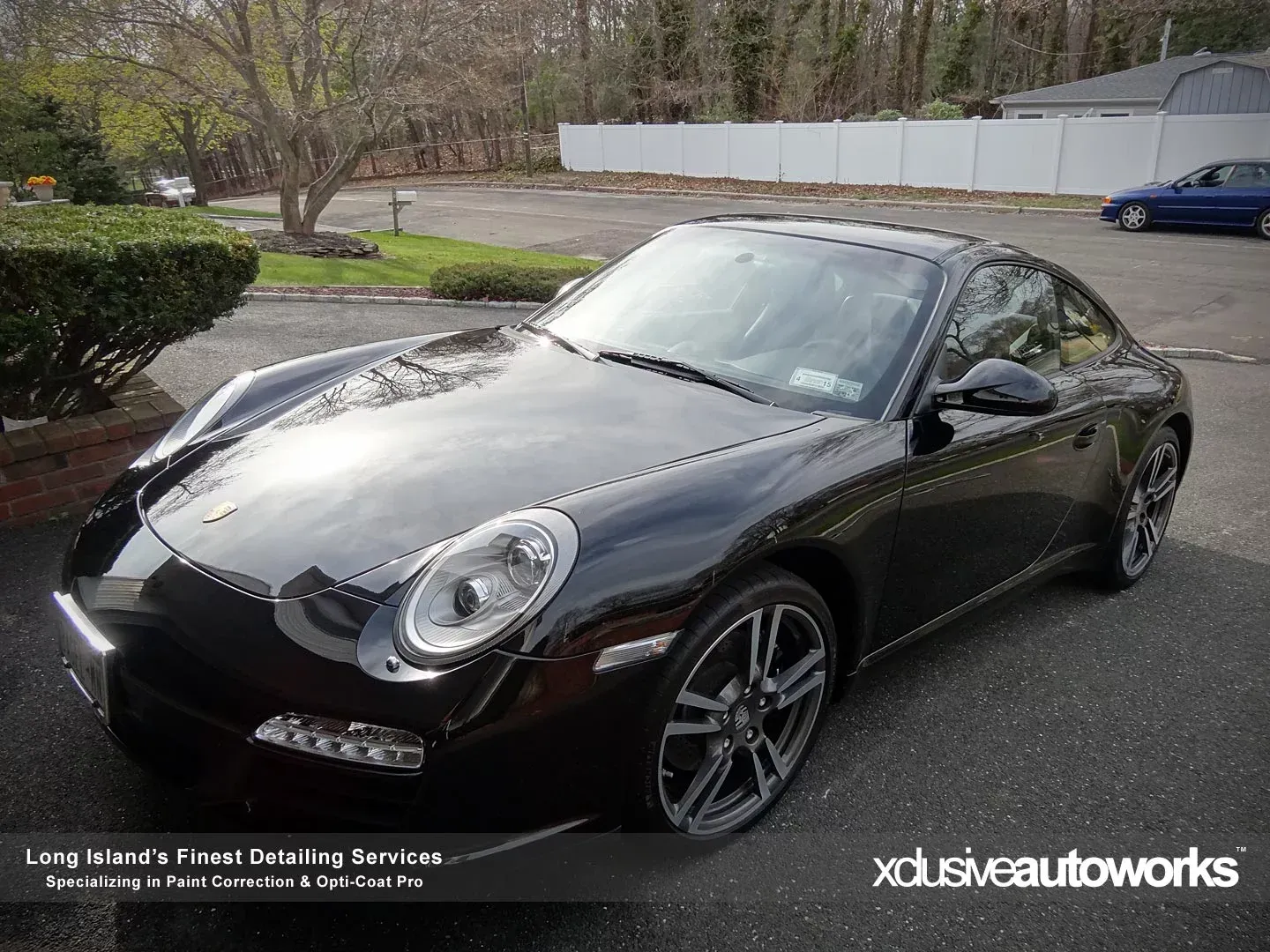 A black porsche 911 is parked in a parking lot.