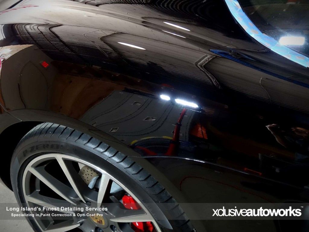 A close up of a black car 's fender and tire