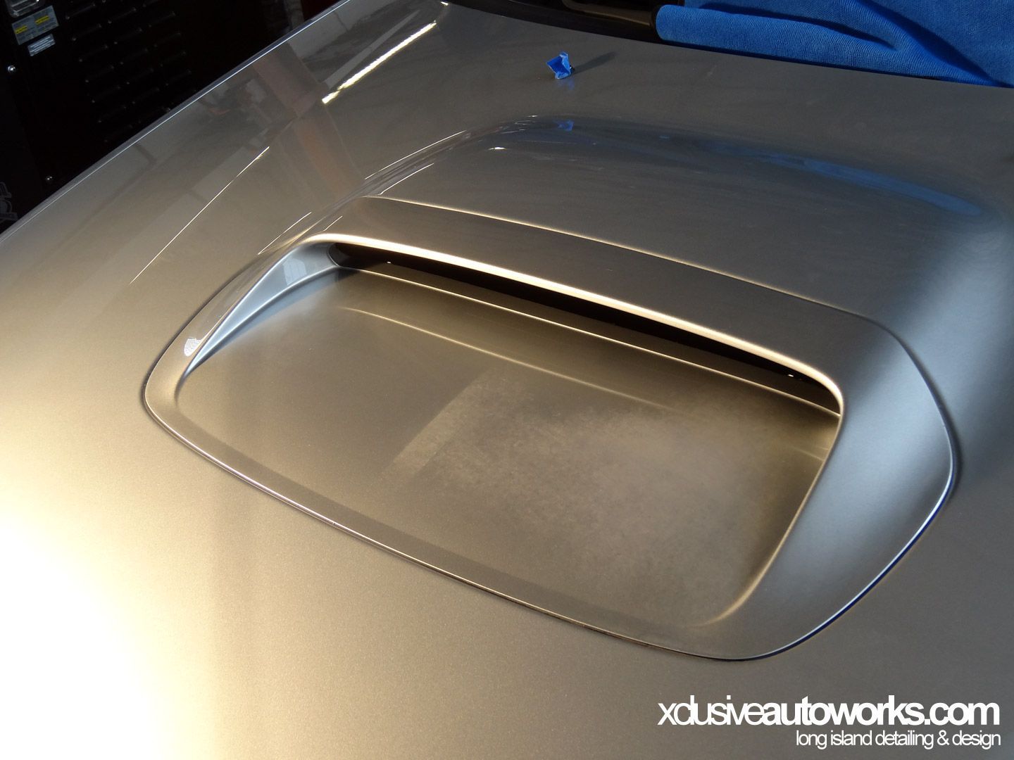 A close up of a car hood that says xdusveautoworks.com