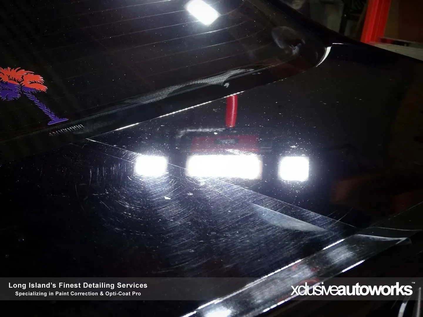 A close up of a black car with the words xclusive autoworks on the bottom