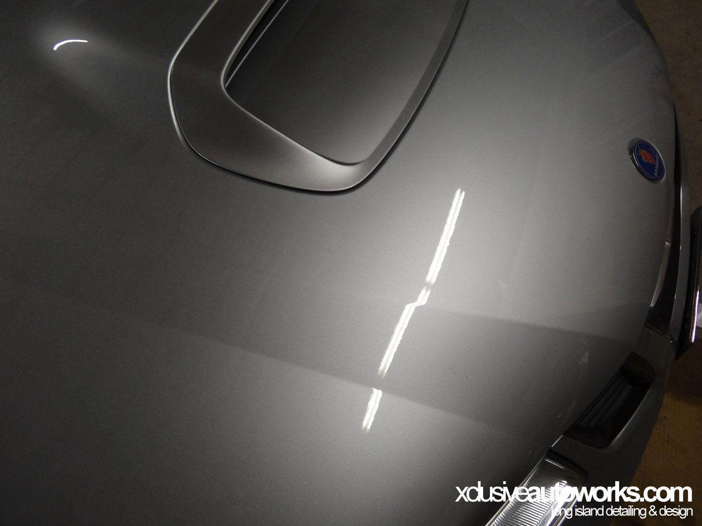 A close up of the hood of a silver car