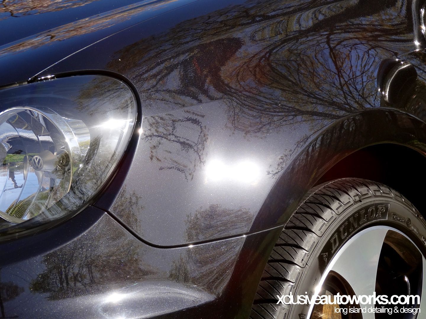 A close up of a car 's headlight and tire.