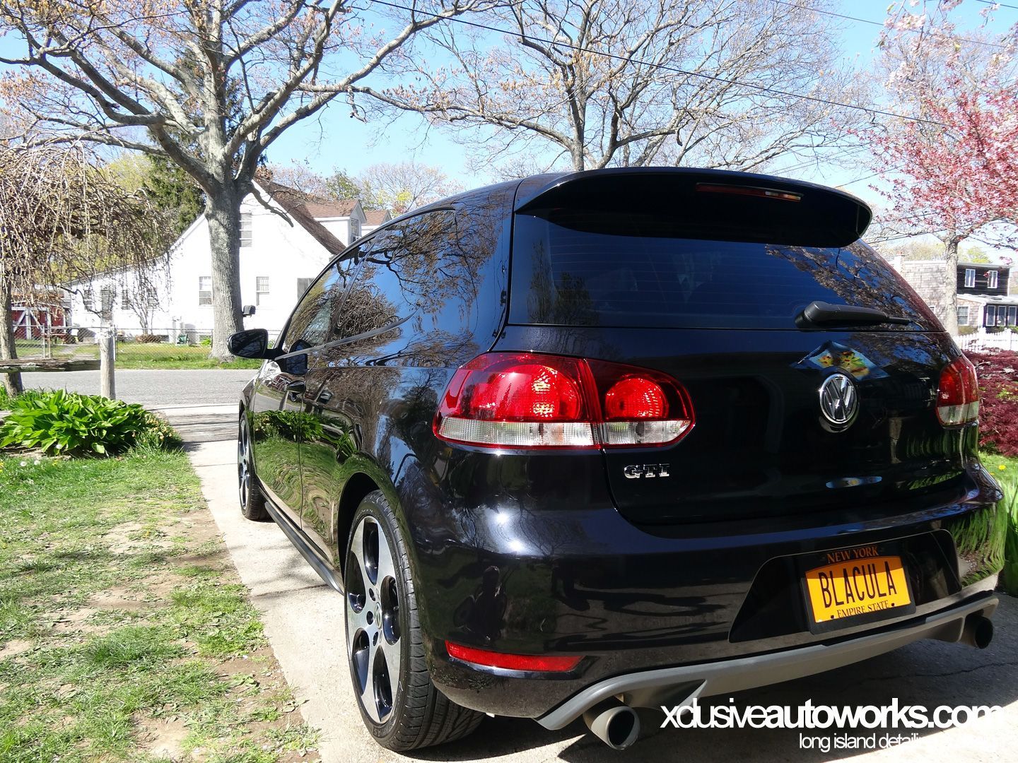 A black volkswagen golf is parked in a driveway