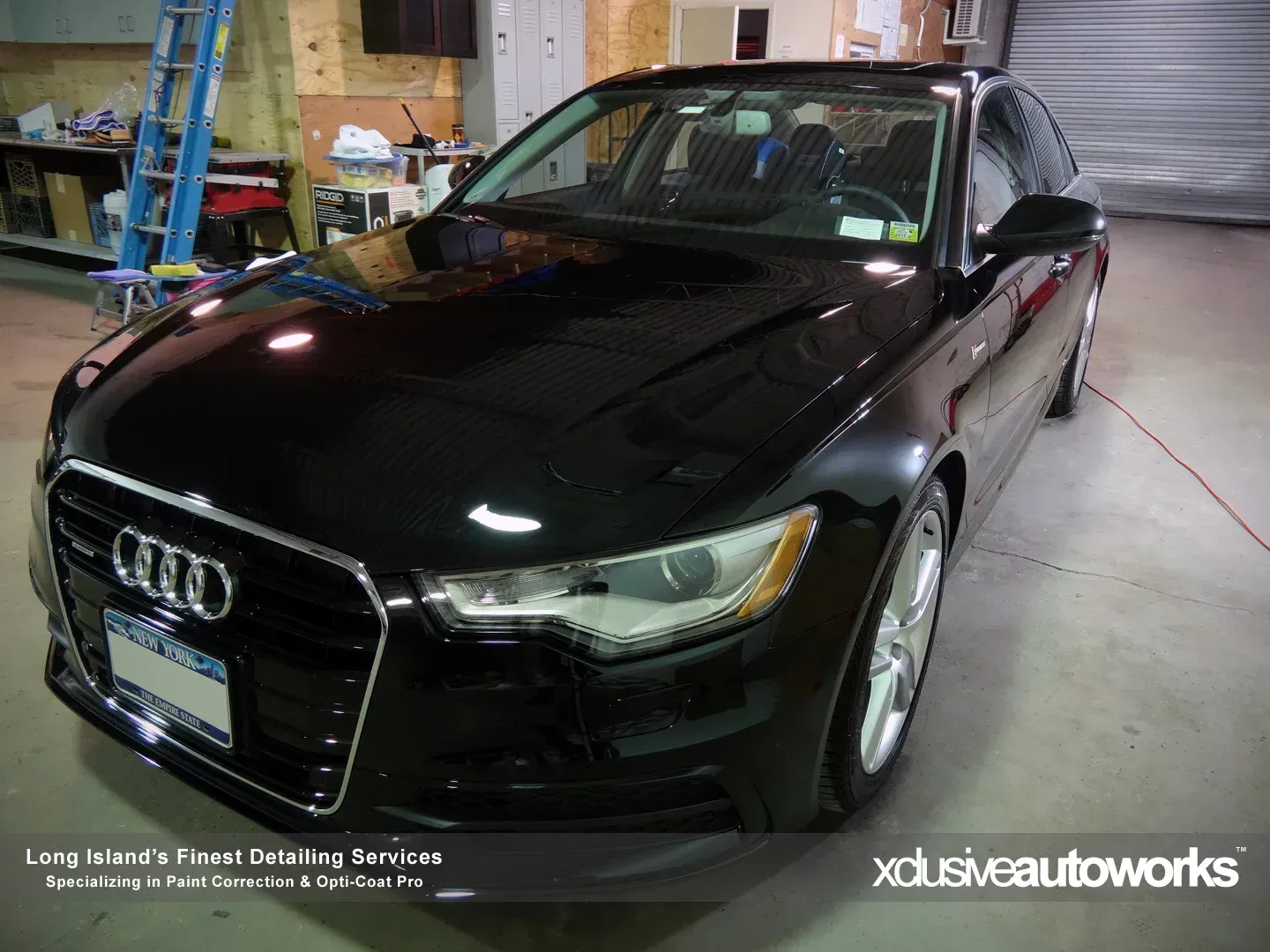 A black audi car is parked in a garage
