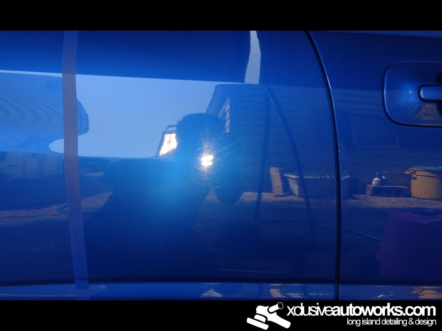 A blue car with the website xdusveautoworks.com on the bottom