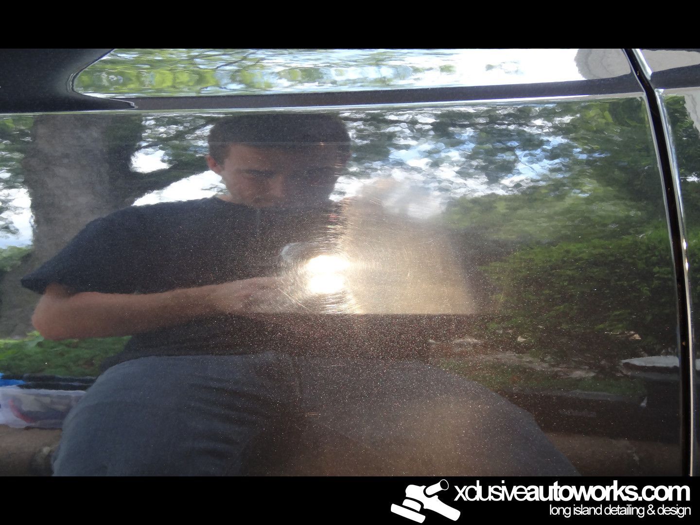 A man is taking a picture of his reflection in a car door