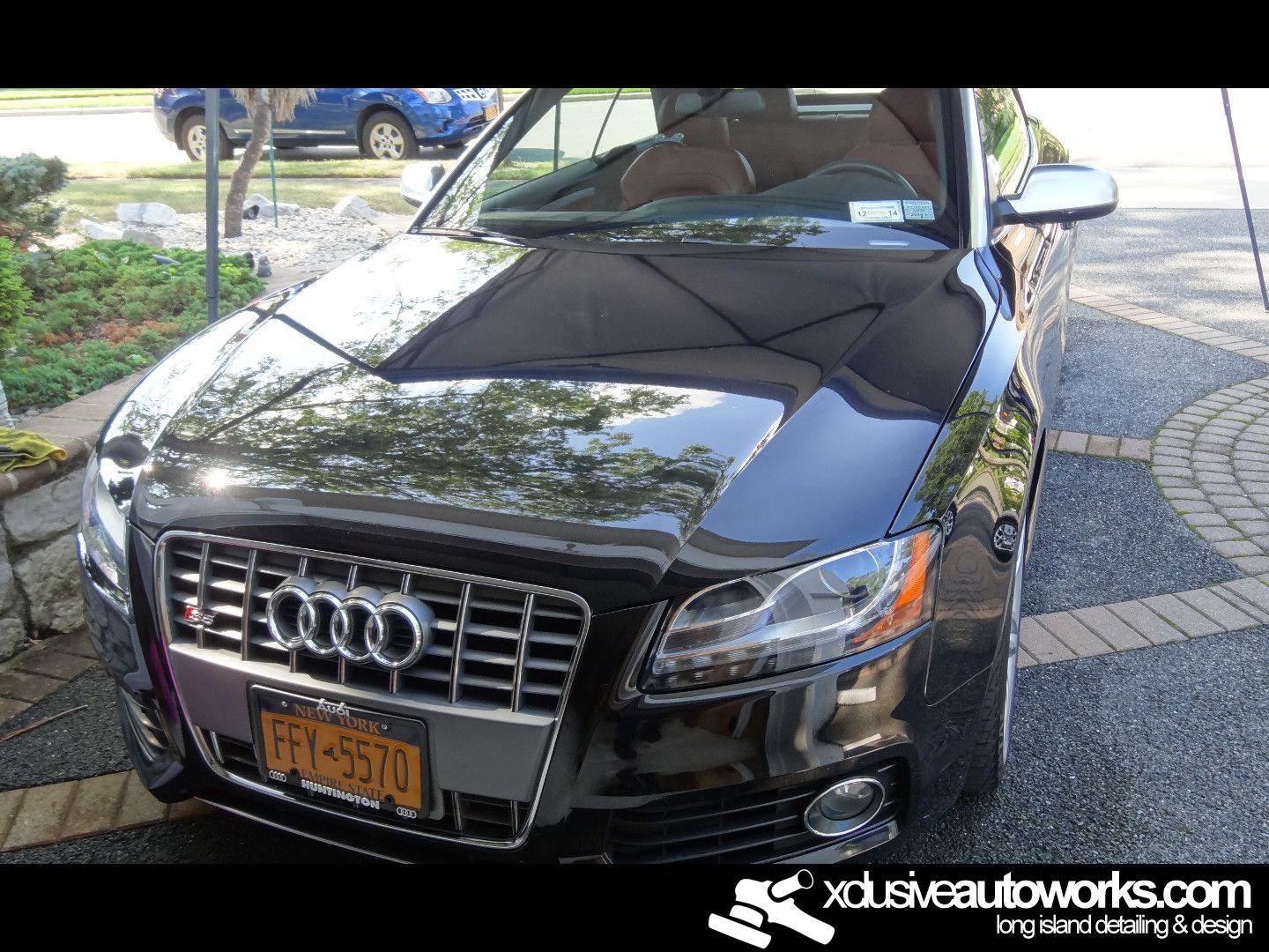 A black audi is parked on the side of the road