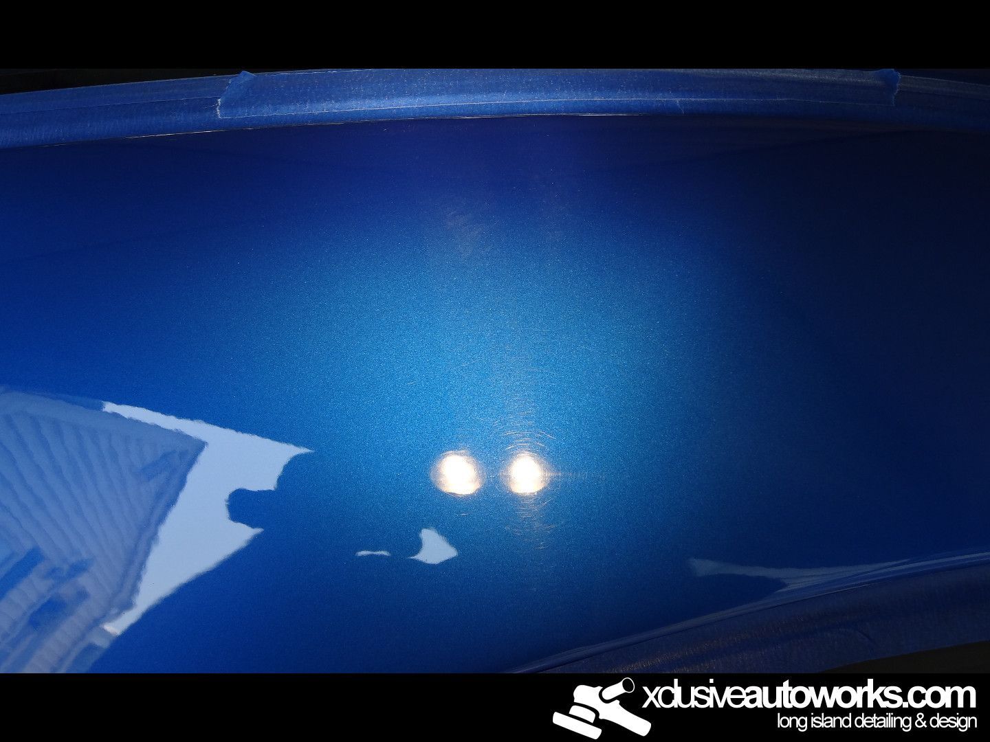 A close up of a blue car with xdusveautoworks.com written on the bottom
