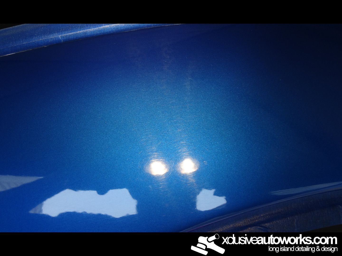 A close up of a blue car with xdusveautoworks.com written on the bottom