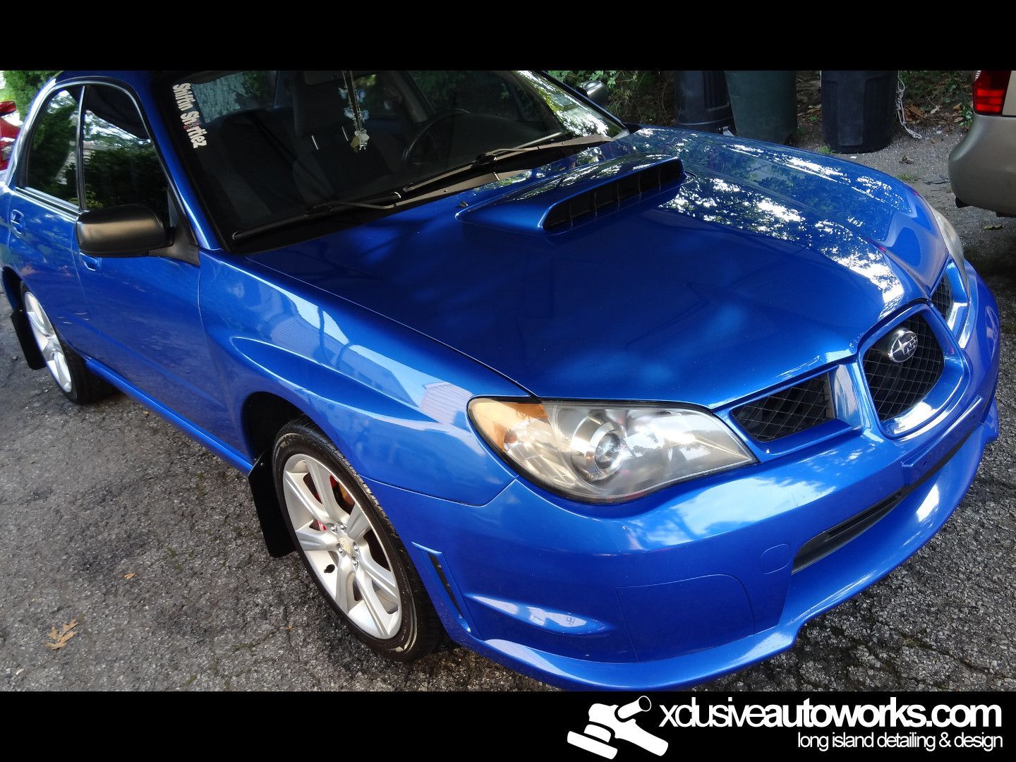 A blue subaru is parked on the side of the road