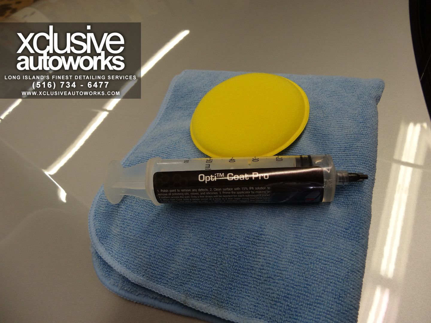 A blue towel with a syringe and a yellow sponge from xclusive autoworks