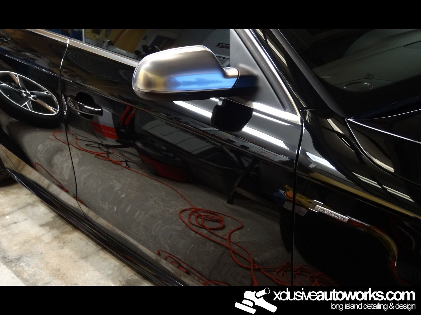 A black car with the website xdusveautoworks.com on the bottom