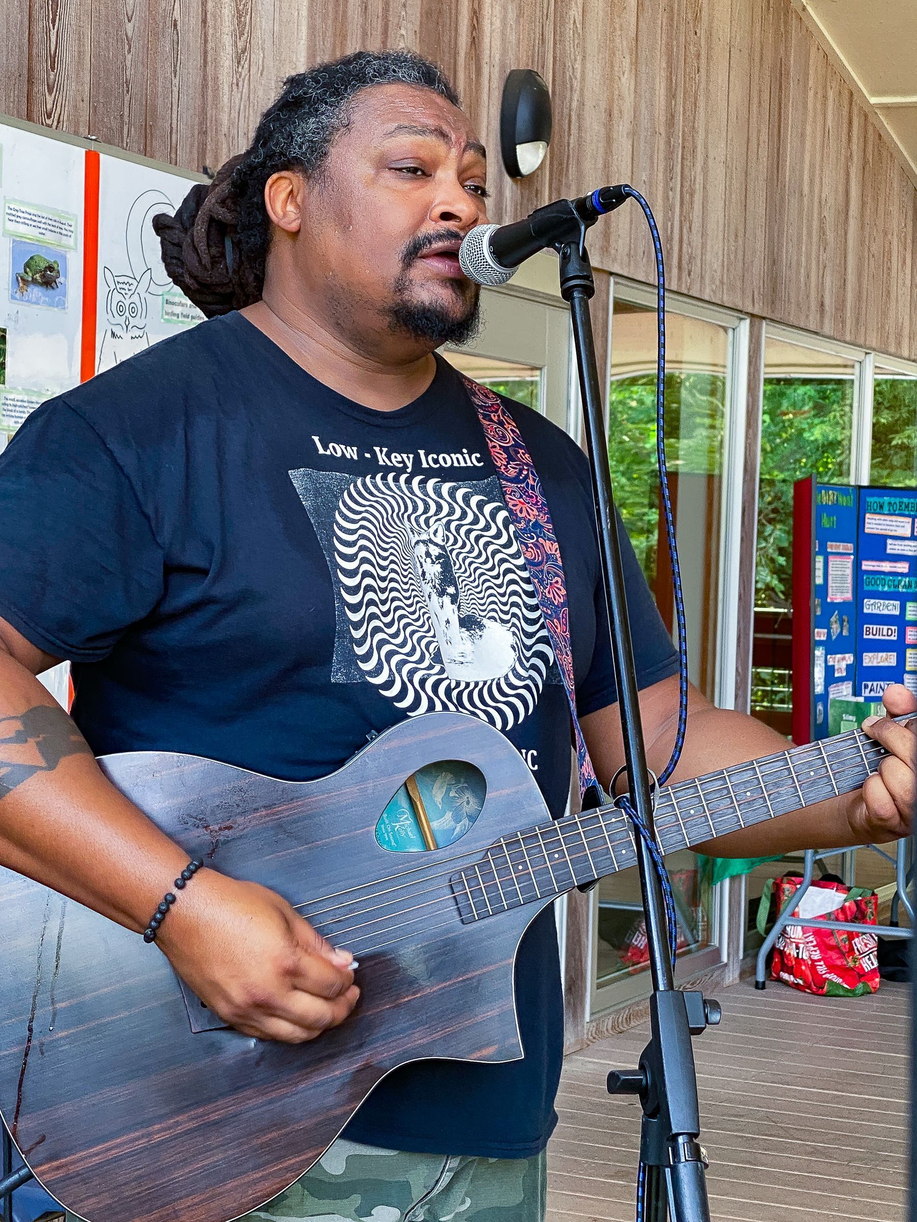 A man singing into a microphone while holding a guitar
