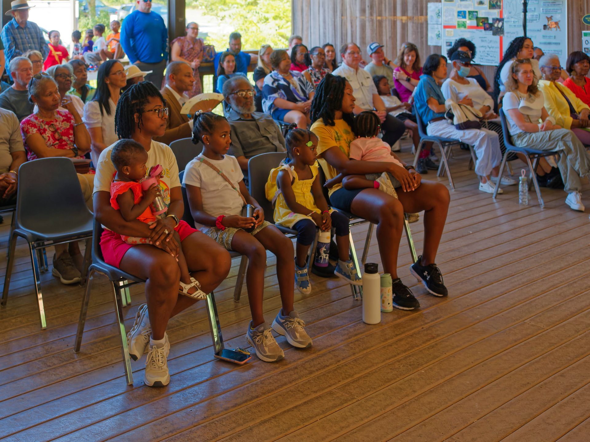 A group of people are sitting in chairs watching a presentation.