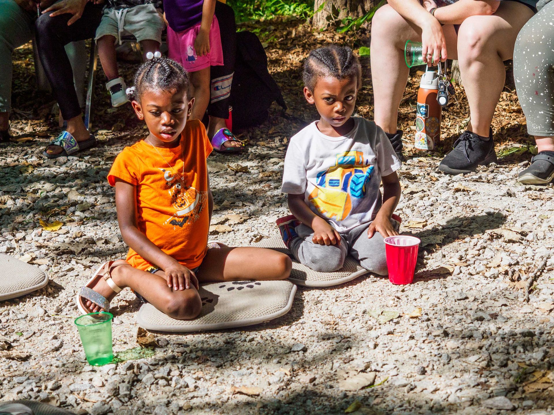 A group of children are sitting on the ground.