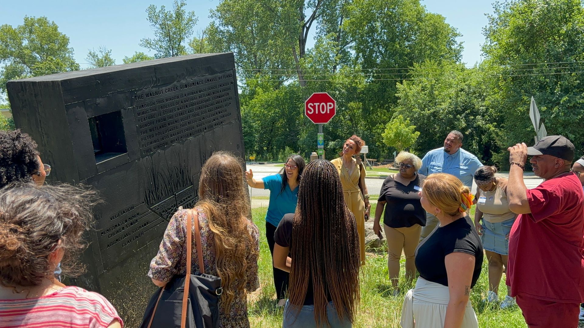 A group of people are standing in front of a stop sign.
