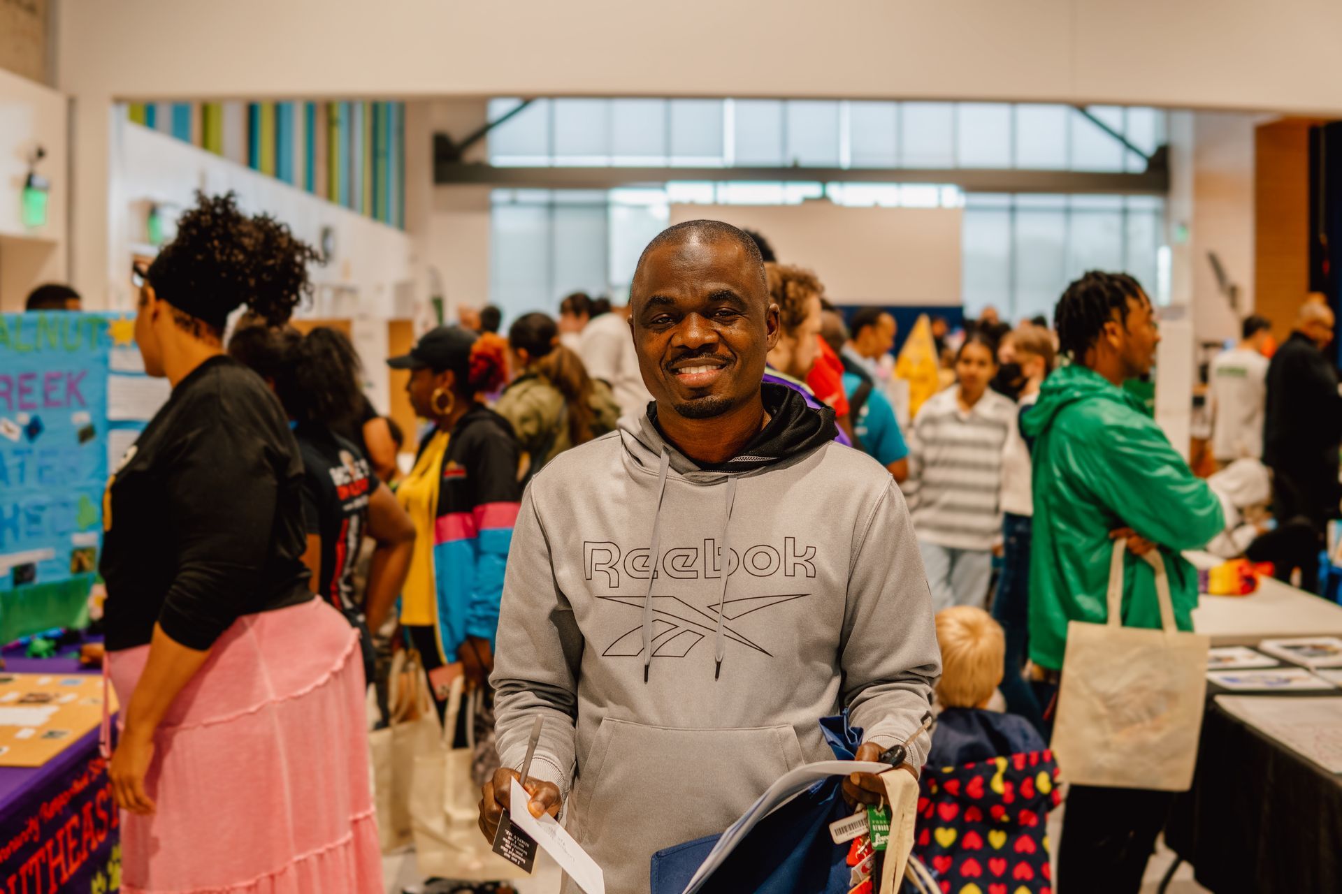 A man is standing in front of a crowd of people at a convention.
