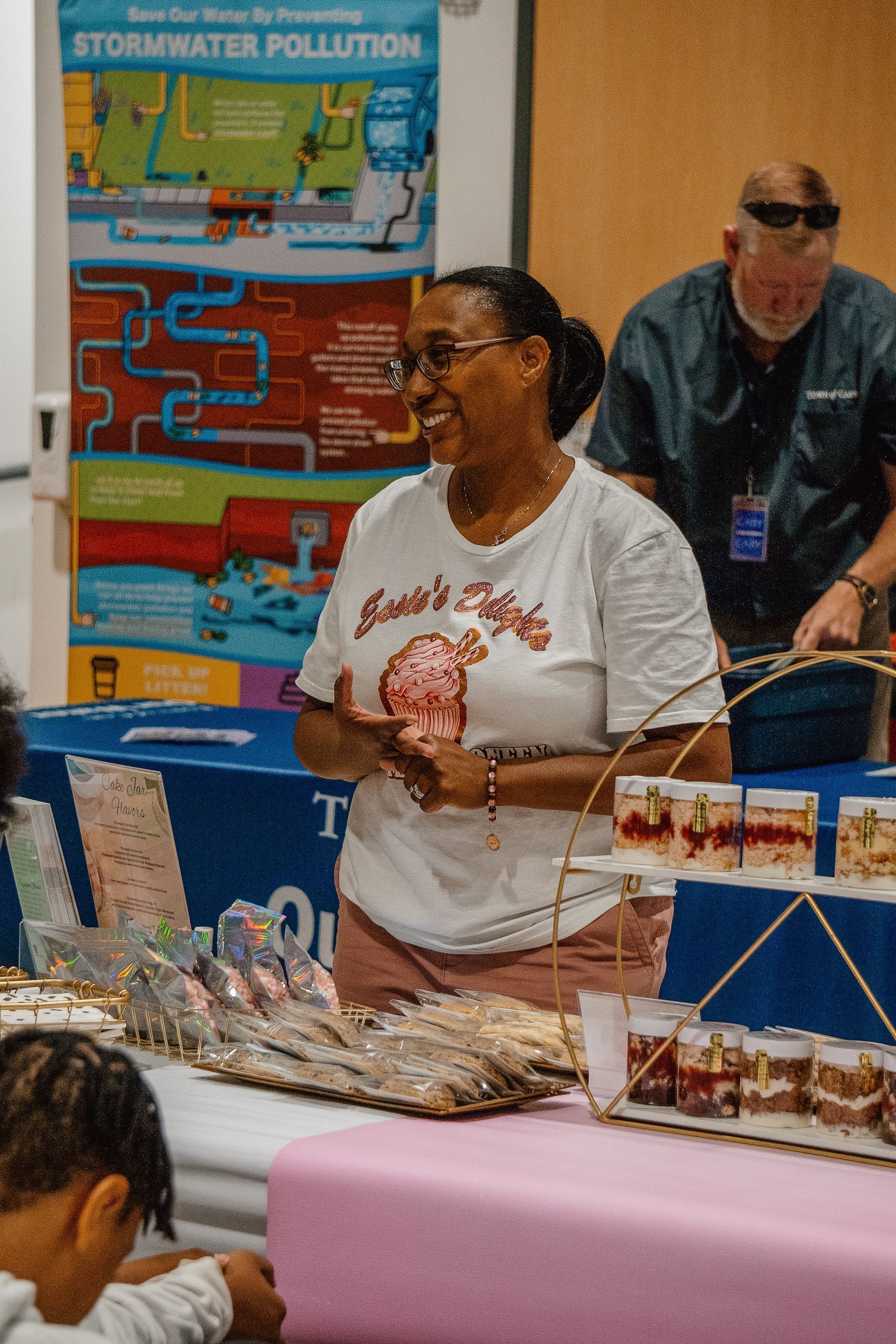 A woman is standing in front of a table with a bunch of food on it.