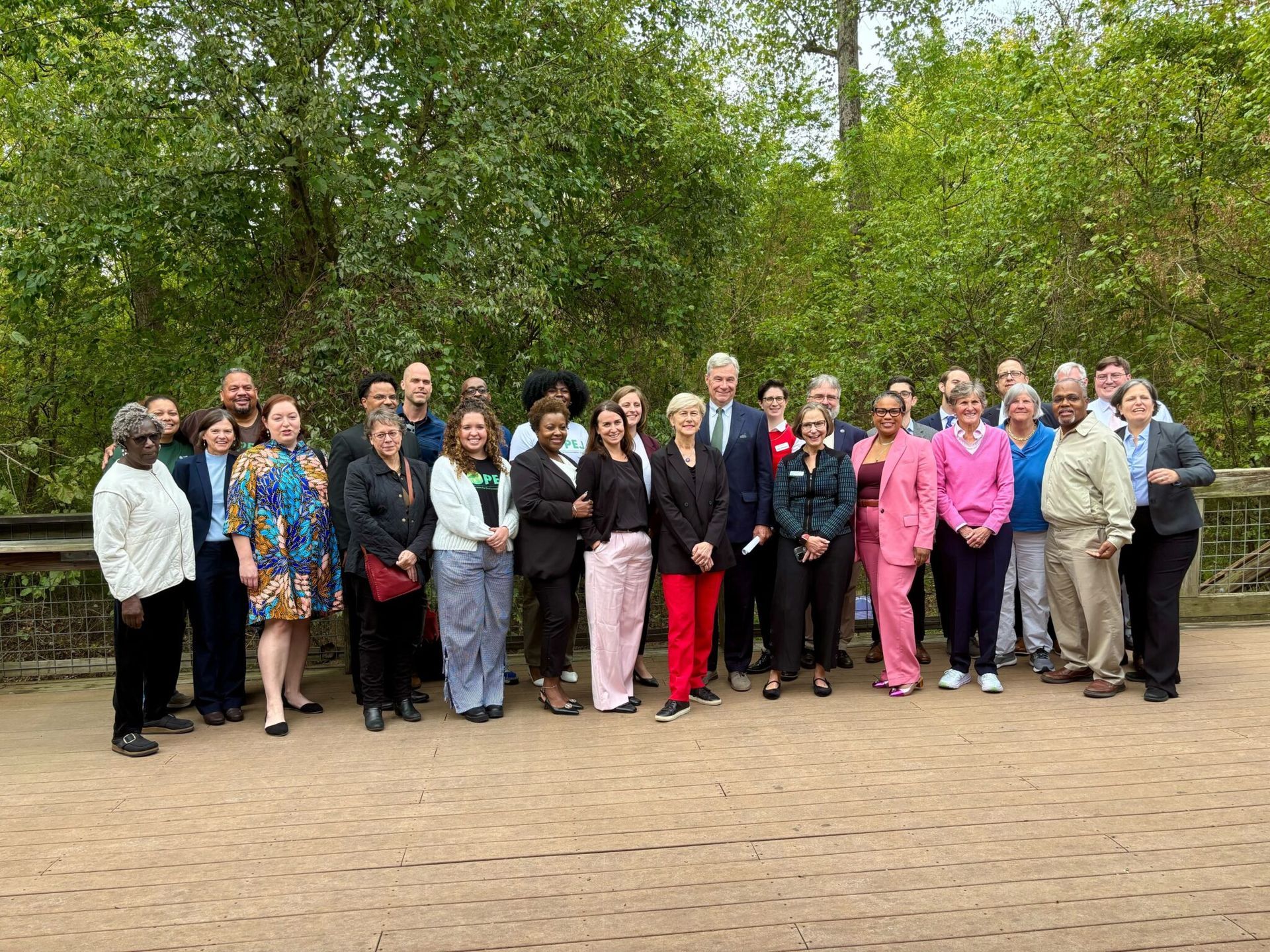 Group of people standing outdoors in a park, posing for a group photo.