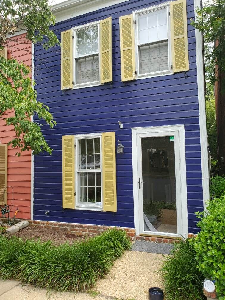 A blue house with yellow shutters and a white door.