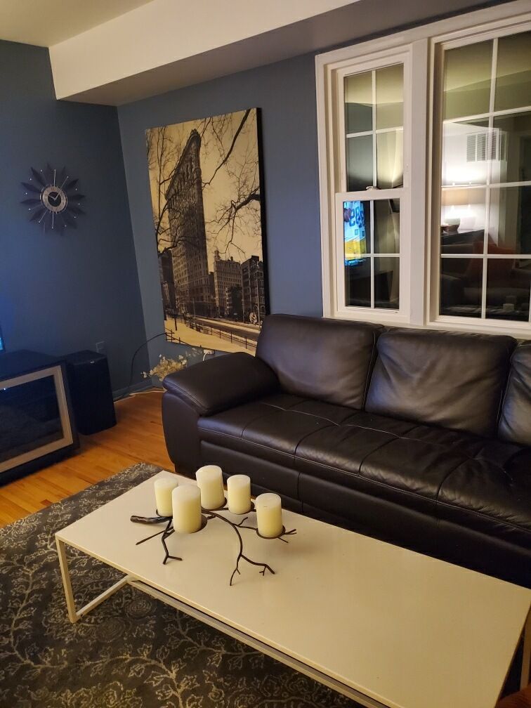 A living room with a couch and a coffee table with candles on it