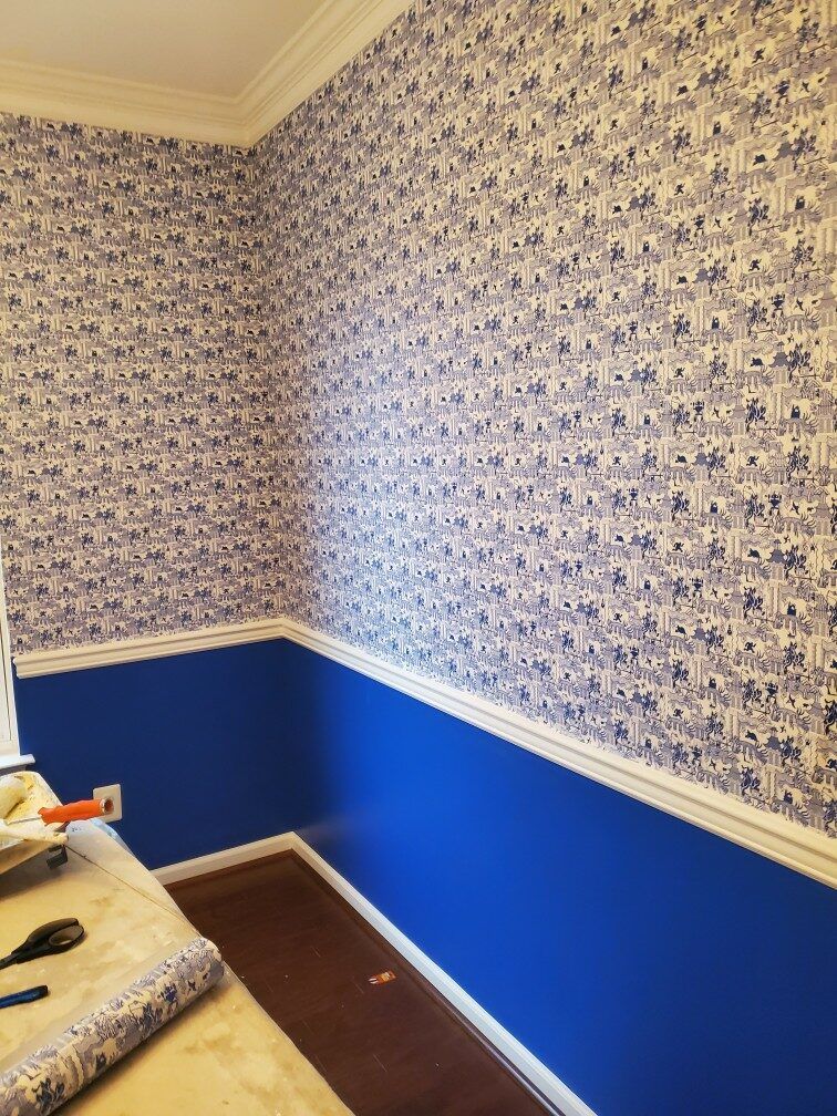A room with blue walls and a floral wallpaper on the wall.