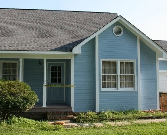Light blue single-story house with a dark roof and covered front porch