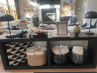 Living room coffee table with woven baskets, bowls, and candles in a modern home setting