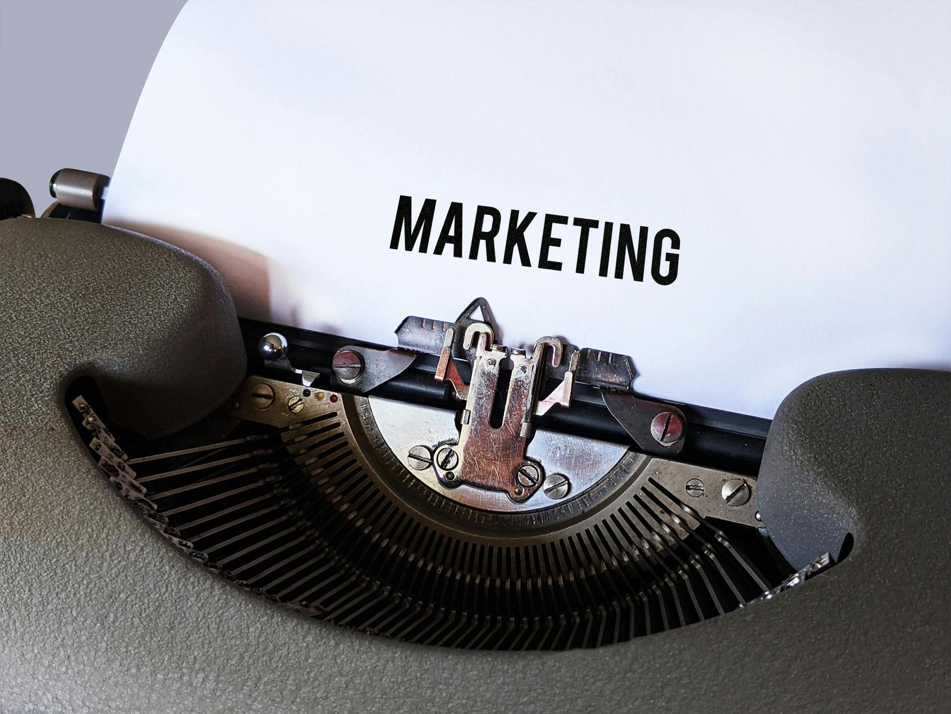 Close-up of a typewriter typing the word “MARKETING” on white paper