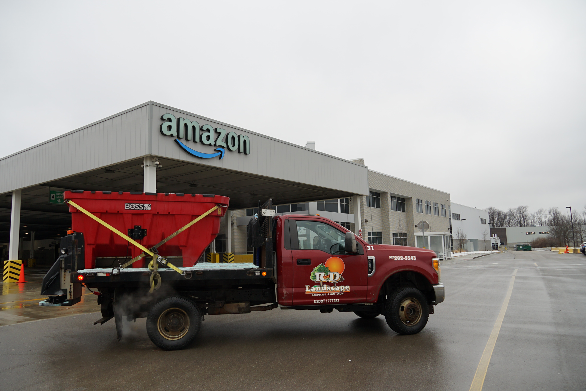 A man is sitting in the driver 's seat of a red truck.