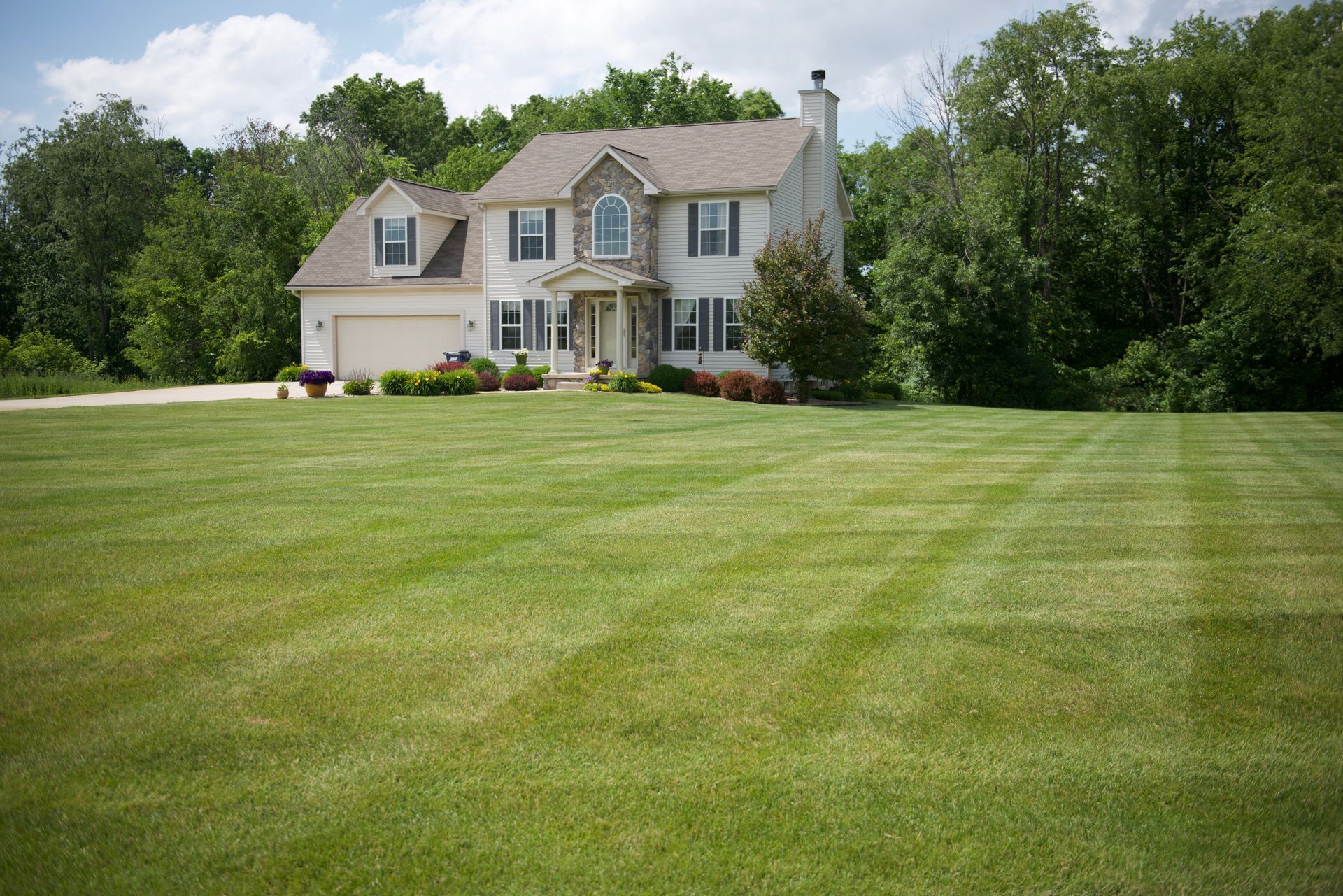 A large house with a lush green lawn in front of it.